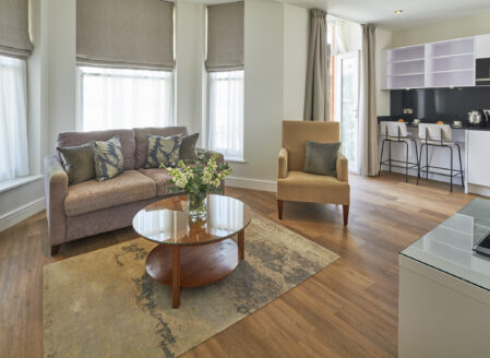 An open-plan living area leading onto the kitchen in a luxury one-bedroom apartment