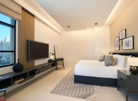غرفة النوم الرئيسية مُجهزة بشاشة تلفزيون ذكية موضوعة في مواجهة السرير