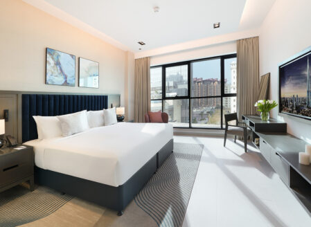 The master bedroom in a superior one-bedroom apartment features a king-size bed