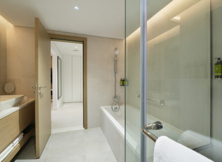 The ensuite bathroom features a bathtub and separate shower